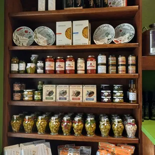 a shelf of olives and balsamics