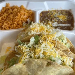Shredded beef crunchy tacos with rice and beans.