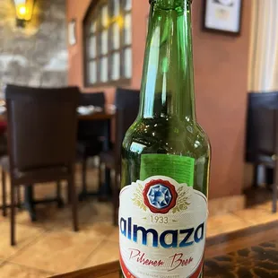 a green beer bottle on a wooden table