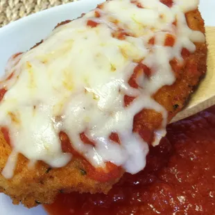 a piece of chicken parmesan with sauce