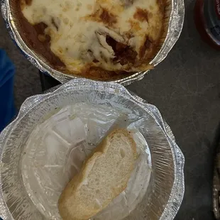 Chicken parmigiana with fettuccine noodles. Empty Caesar salad in the middle with a piece of the bread they include with your entree