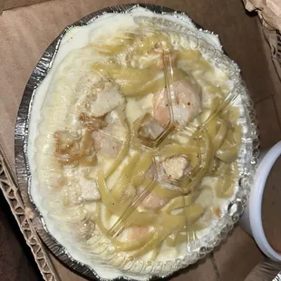 Pasta with the container on. Alfredo sauce spilling out