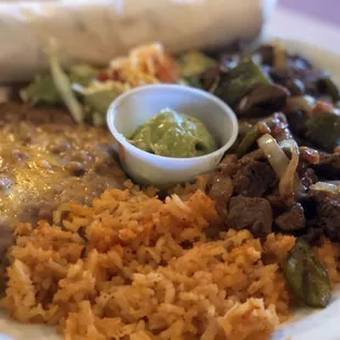 Beef tips, peppers, onions, rice and beans.