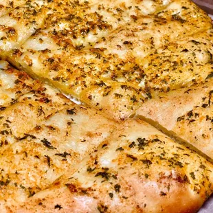 a sliced pizza with cheese and herbs