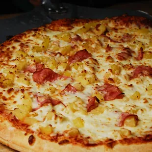 a pizza with pineapple and ham