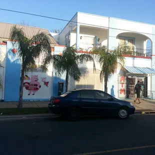 a black car parked in front of a blue building