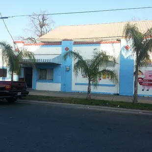 a red truck parked in front of a blue building