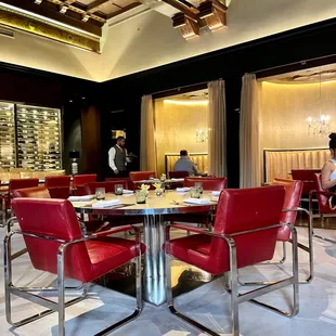 a dining room with a round table and red chairs