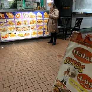 a woman standing in front of a food stand