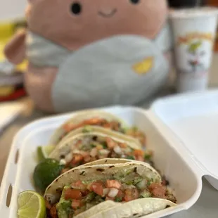 three tacos in a styrofoam container