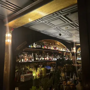 a dimly lit bar with a lot of bottles on the shelves