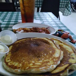 a plate of pancakes with bacon and eggs