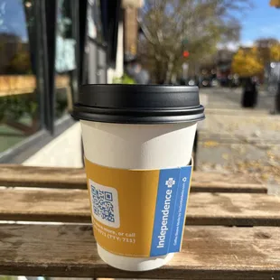 a cup of coffee on a bench