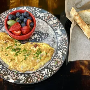 Meat and cheese omelet with two sides of fruit and homemade Turkish bread