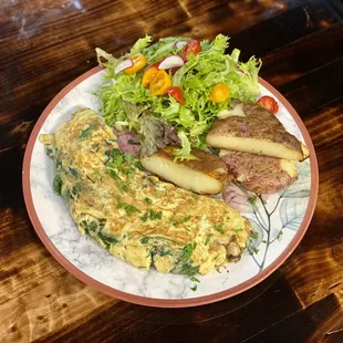 Veggie omelet with two sides of green salad and baked potatoes