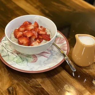 Hot oatmeal with strawberries and almond milk for vegan and dairy free guests