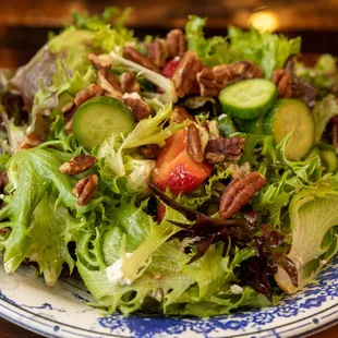 Alihan's salad with cucumbers, strawberries, greens, white soft cheese, and pecans