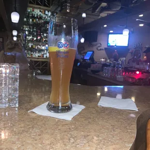a glass of beer on a bar