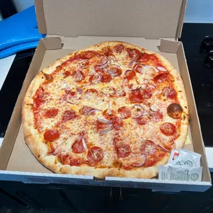 Giant pizza with very sparse red onion and pepperoni. Rather pay Pizza Hut
