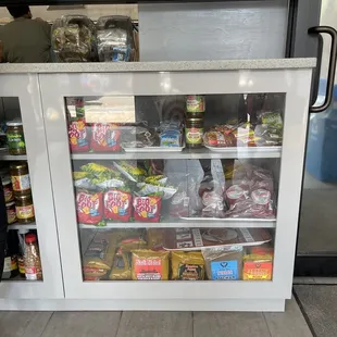 a woman standing in front of a refridgerator