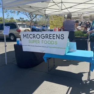 a table with a sign that says microgreens open foods