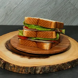 a sandwich on a wooden plate