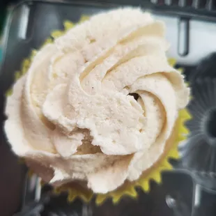 a frosted cupcake in a muffin tin