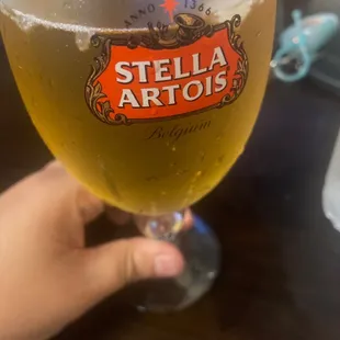 a hand holding a glass of beer