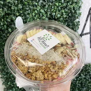 a hand holding a bowl of granola