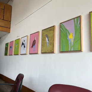 a row of paintings on the wall