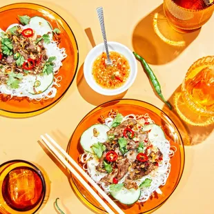 two plates of food with chopsticks