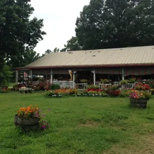 a farm house with flowers in front of it