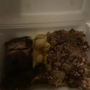 Small Jerk chicken meal with Mac and cheese and rice and peas (sorry it's so dark)