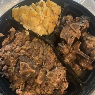 Oxtails with Mac and cheese and rice and peas.