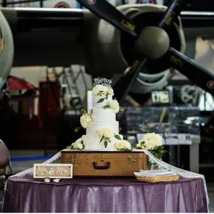 a wedding cake on a table in front of an airplane