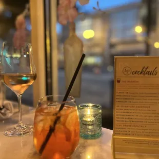 a glass of wine and a menu on a table