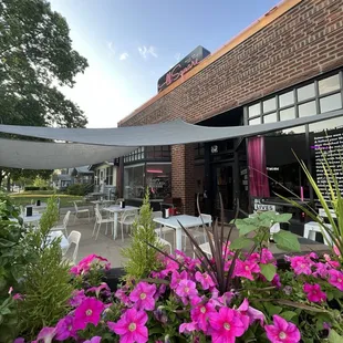 the outside of a restaurant with tables and chairs