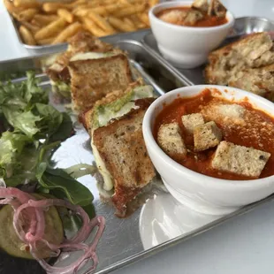 a tray of food including a sandwich, salad, and french fries