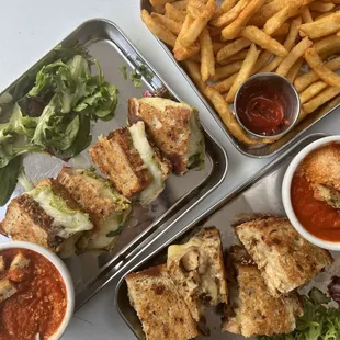 a tray of food including a sandwich, french fries, and salad