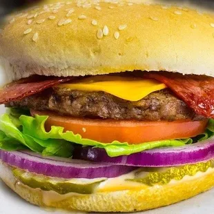 a hamburger with cheese, lettuce, tomato, and onion
