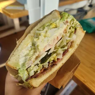 half of a cobb salad sandwich: egg salad with bacon and avocado