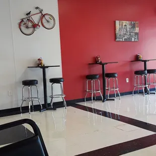 a red wall and black stools