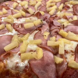 a pizza with pineapples and ham