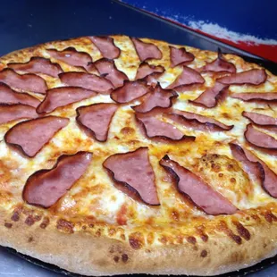 a pizza with ham and cheese