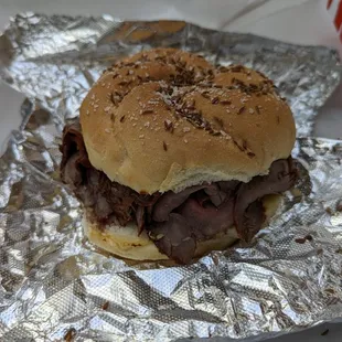 a beef sandwich wrapped in aluminum foil