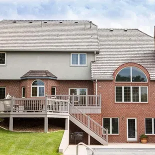 a brick home with a deck and stairs