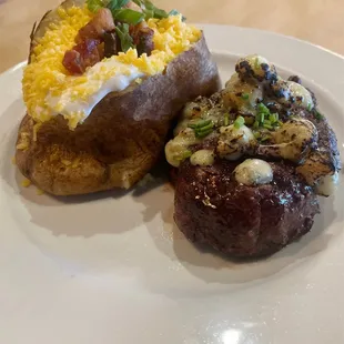 medium rare filet covered in butter and brûlées blue cheese with a loaded baked potato