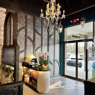 a lobby with chandelier and furniture