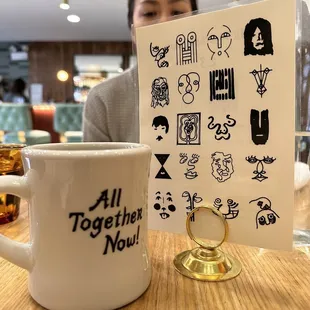 a woman sitting at a table with a cup of coffee