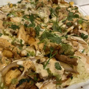 Somali rice with grilled chicken topped with onions, peppers, corn, cilantro, and three sauces (SW ranch, green chili, fav sauce).